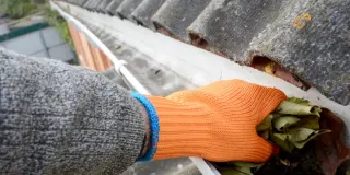 Szakember létrán állva tisztítja az ereszcsatornát a falevelektől és szennyeződésektől Zalaegerszegen